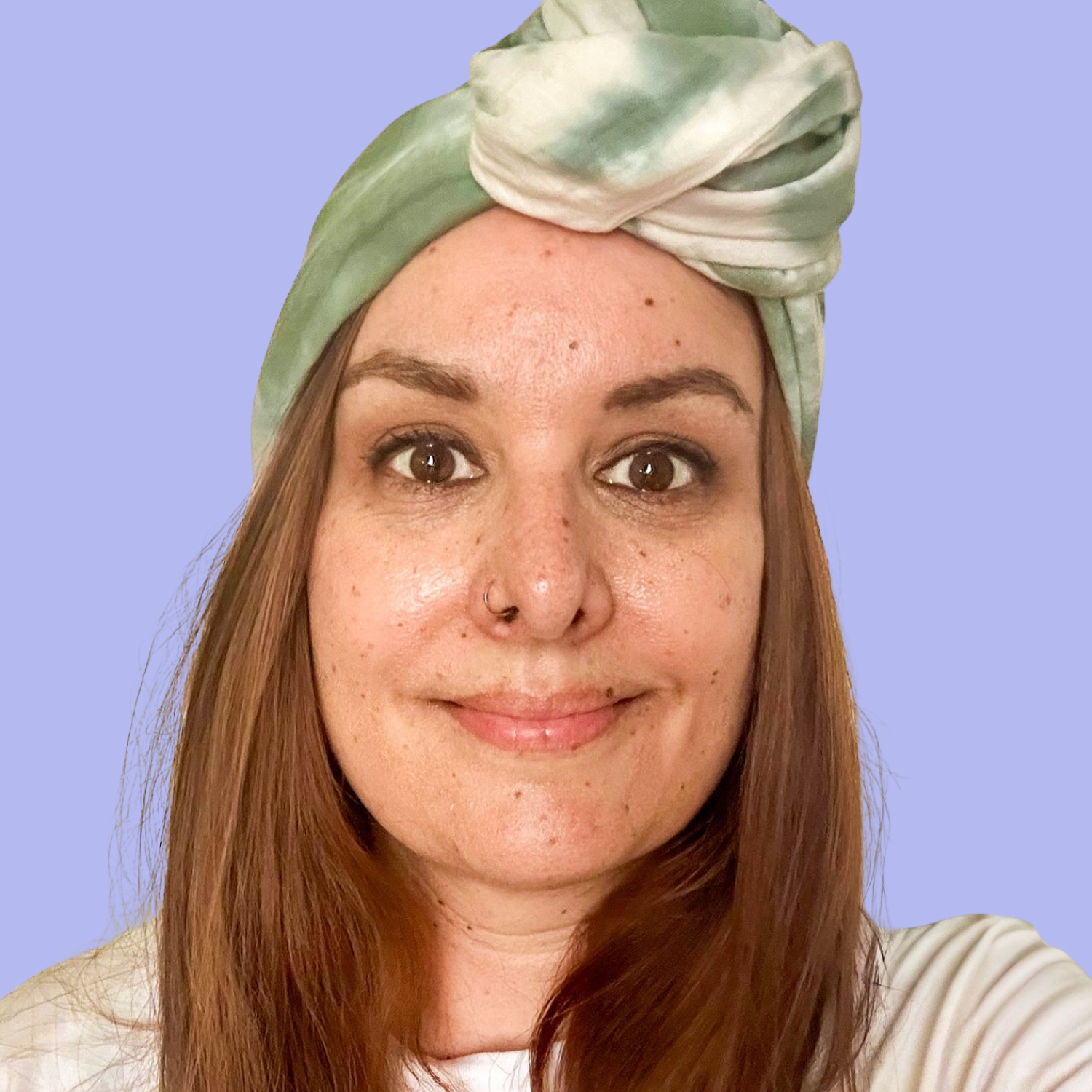 Jasmin hat lange braune Haare, trägt eine Bille und eine grünen Turban.