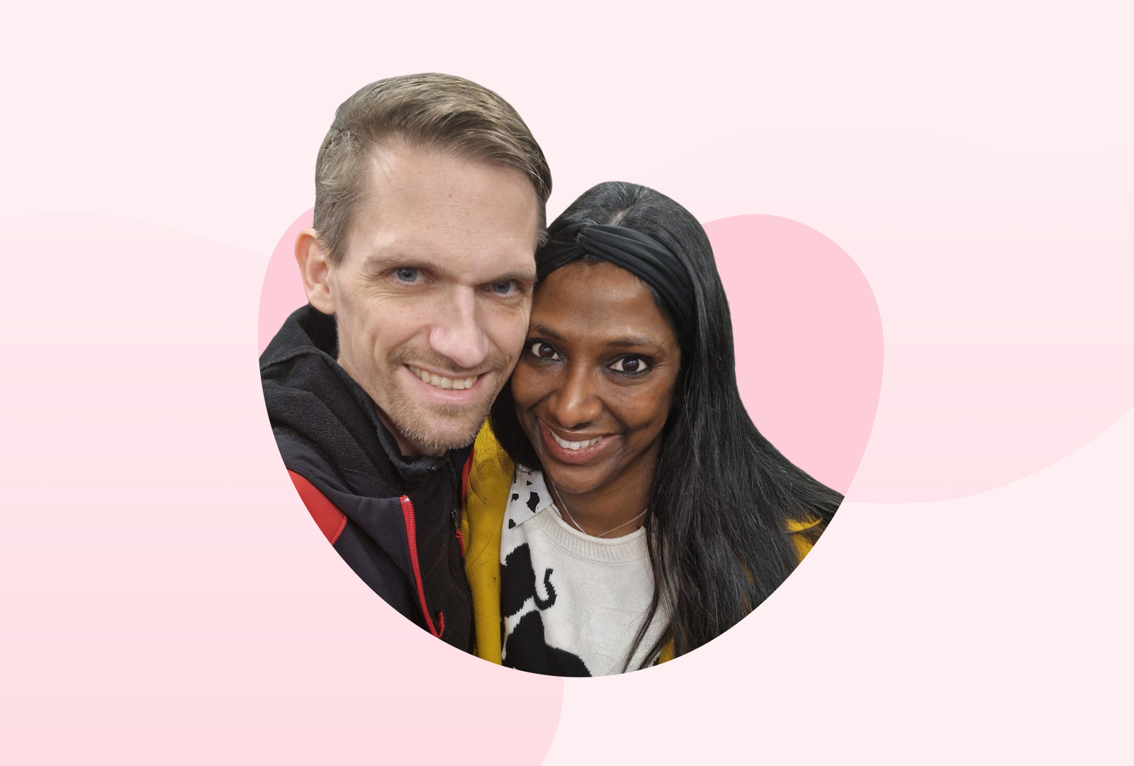 Freddy, links im Bild und Nadine, rechts im Bild, lächeln, die Köpfe dicht beieinander, in die Kamera.