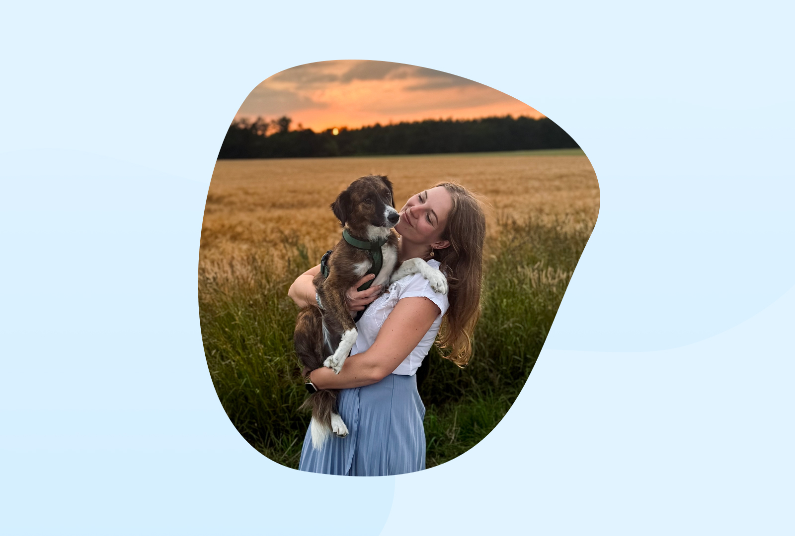 Birte hält ihren Hund in den Armen und lächelt ihn an.