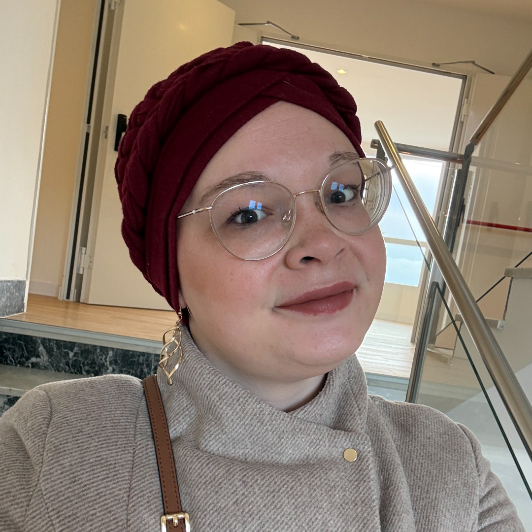 Alina trägt eine Brille und einen Turban während sie ein Selfie macht.