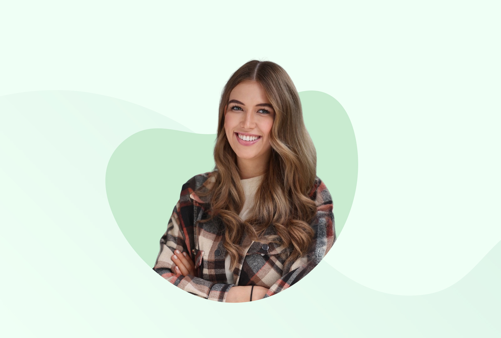 Eva trägt eine karierte Bluse und hat die Arme ineinander verschränkt, während sie in die Kamera strahlt.