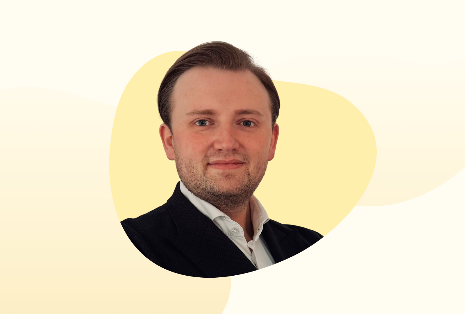 Florentin trägt ein weißes Hemd, darüber eine schwarze Jacke und lächelt in die Kamera.