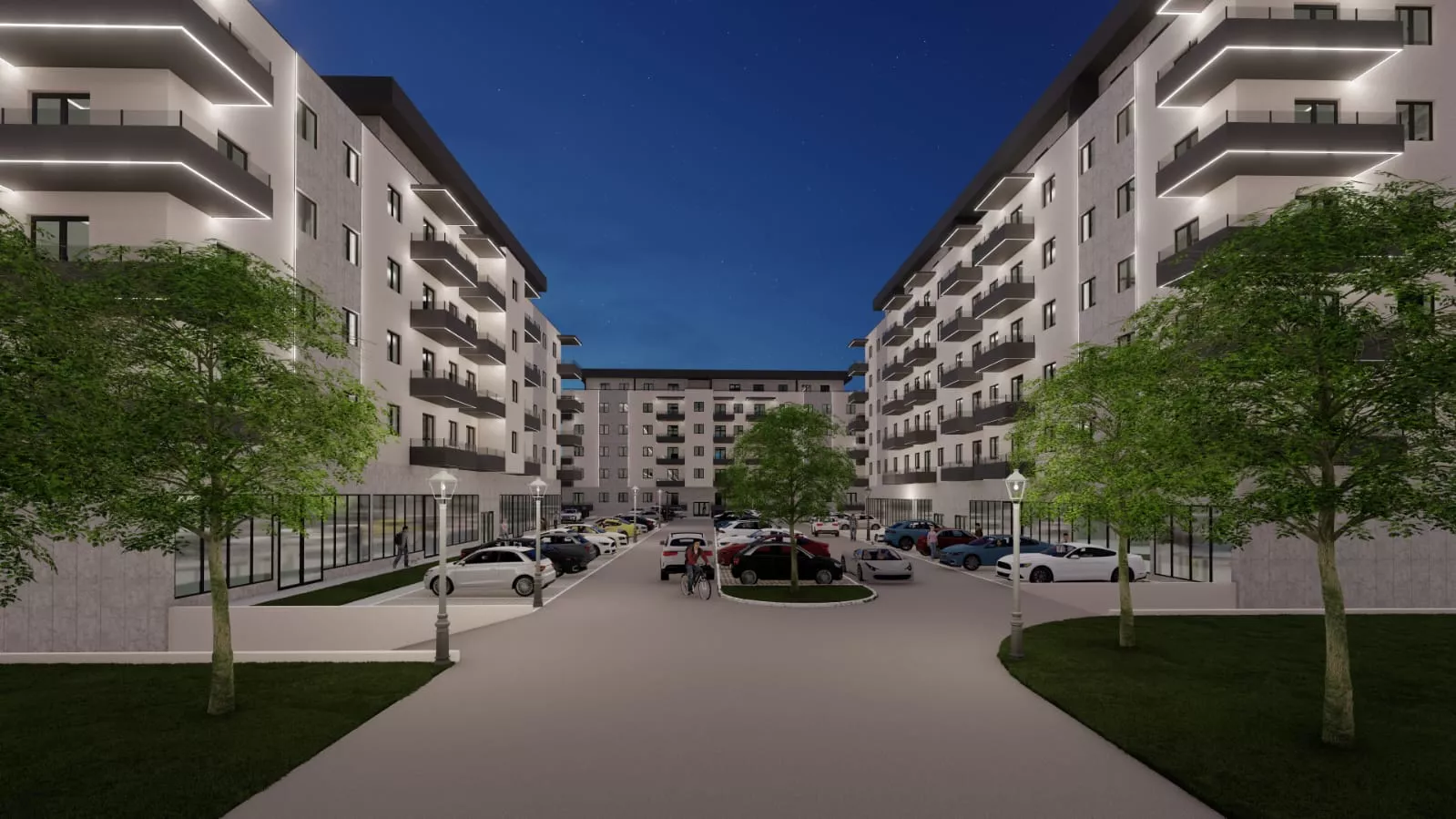 Night view of a modern apartment complex with lit balconies, trees, parked cars, and street lamps along the driveway.