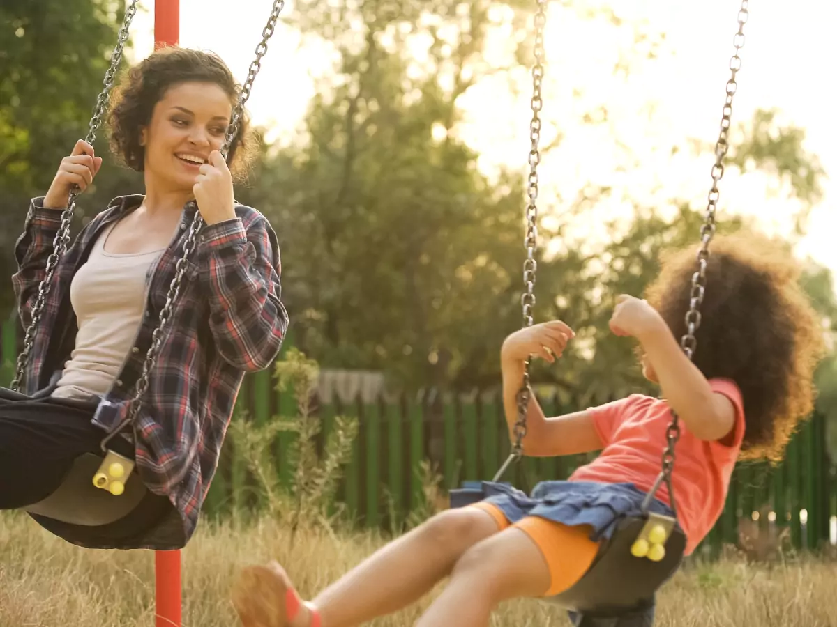 majka i dete se ljuljaju u parku