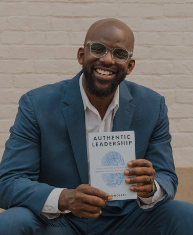 dan holding up his authentic leadership book