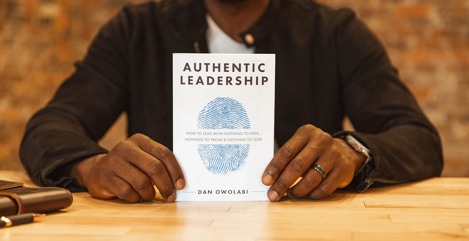 dan holding authentic leadership book on table