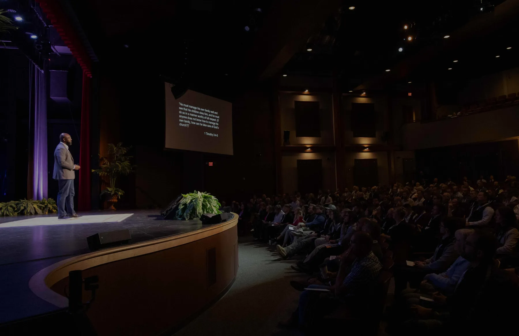 dan speaking to audience from stage with overlay