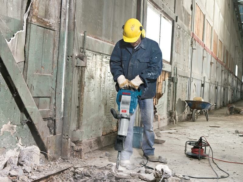 Man using road breaker on concrete floor