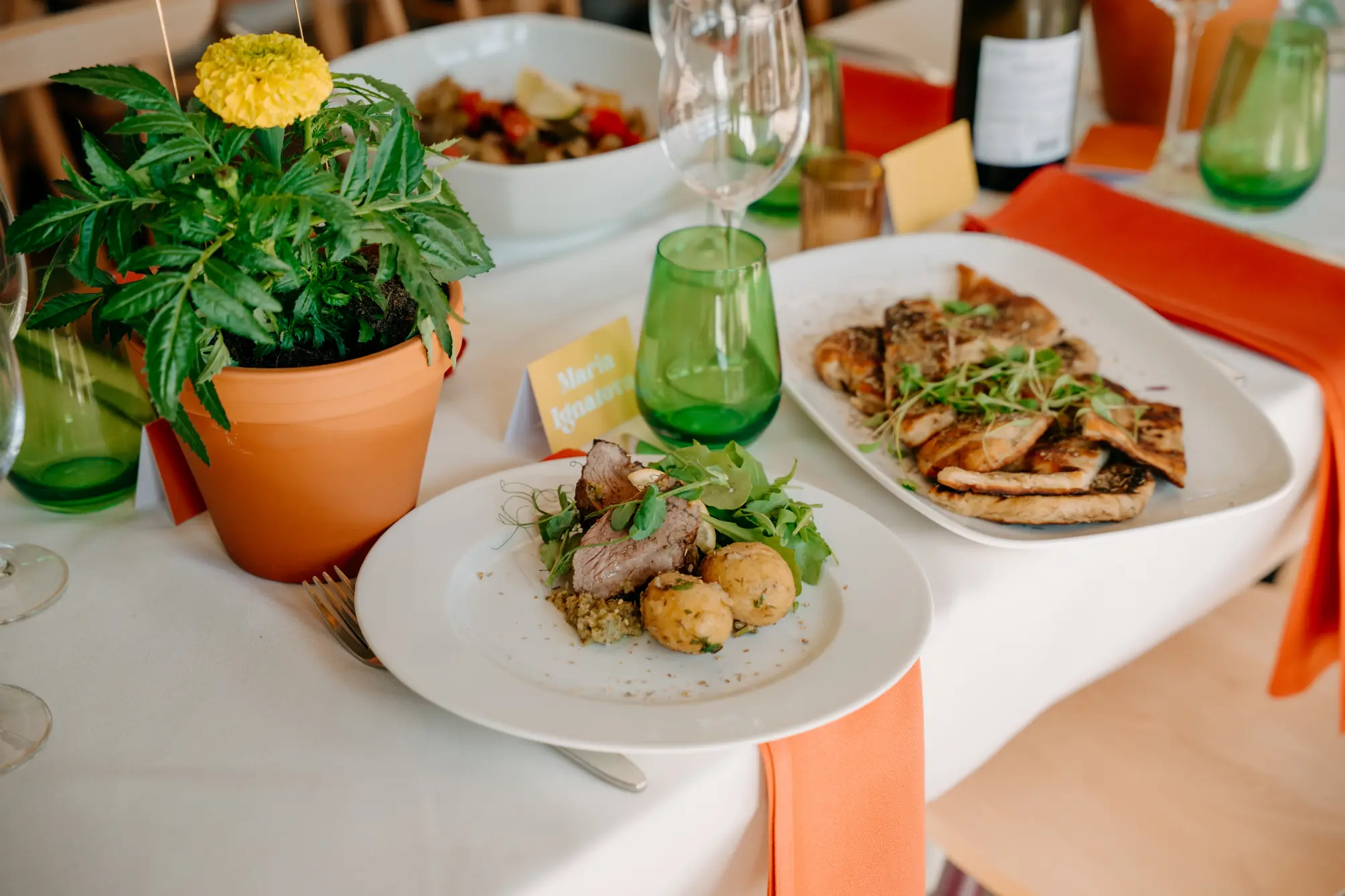 The chef plates a mouthwatering steak dinner with carrots, potatoes, and herbs at a catering event in Sussex.