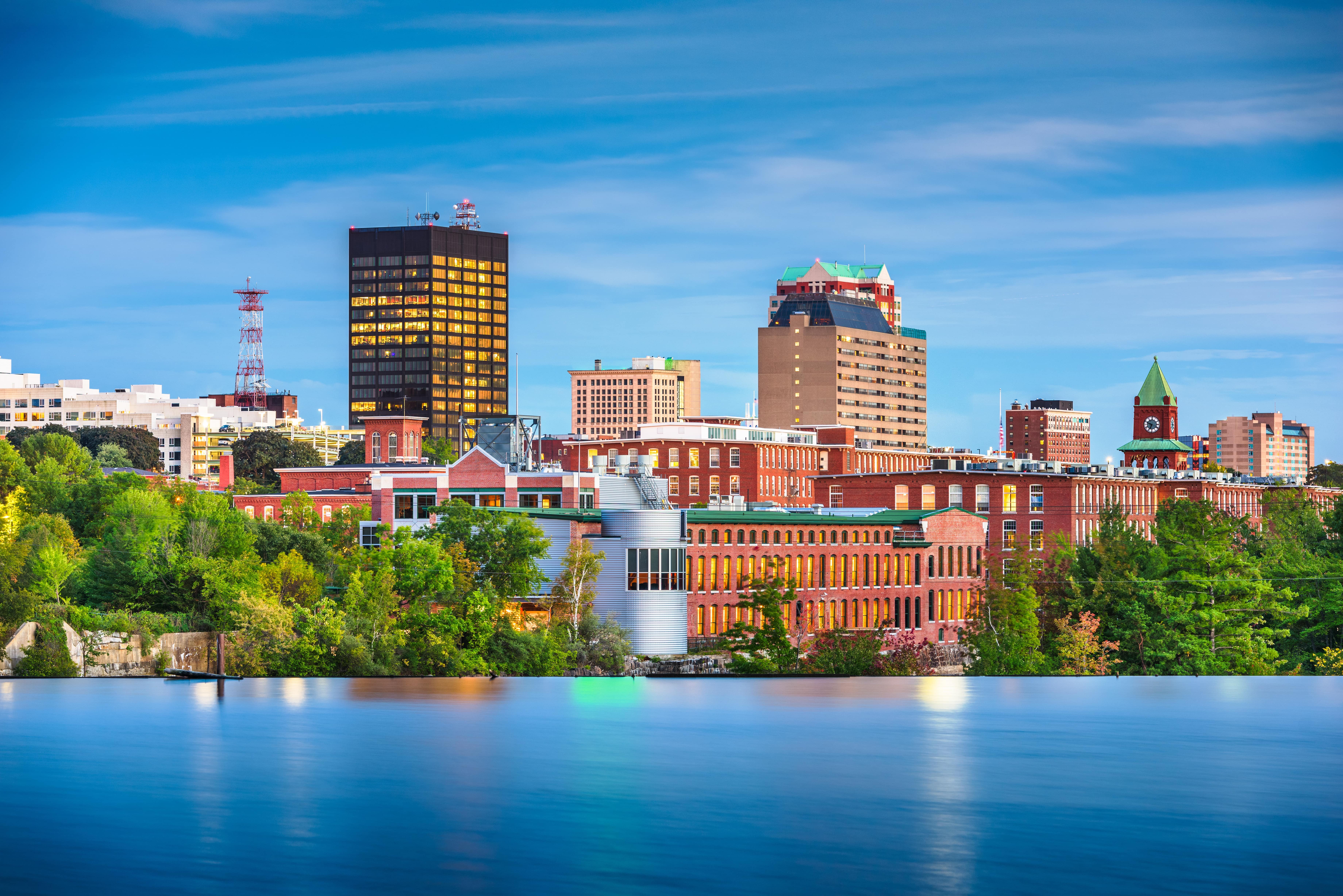 Manchester, NH skyline along the Merrimack River—serving anxiety & EMDR therapy clients.