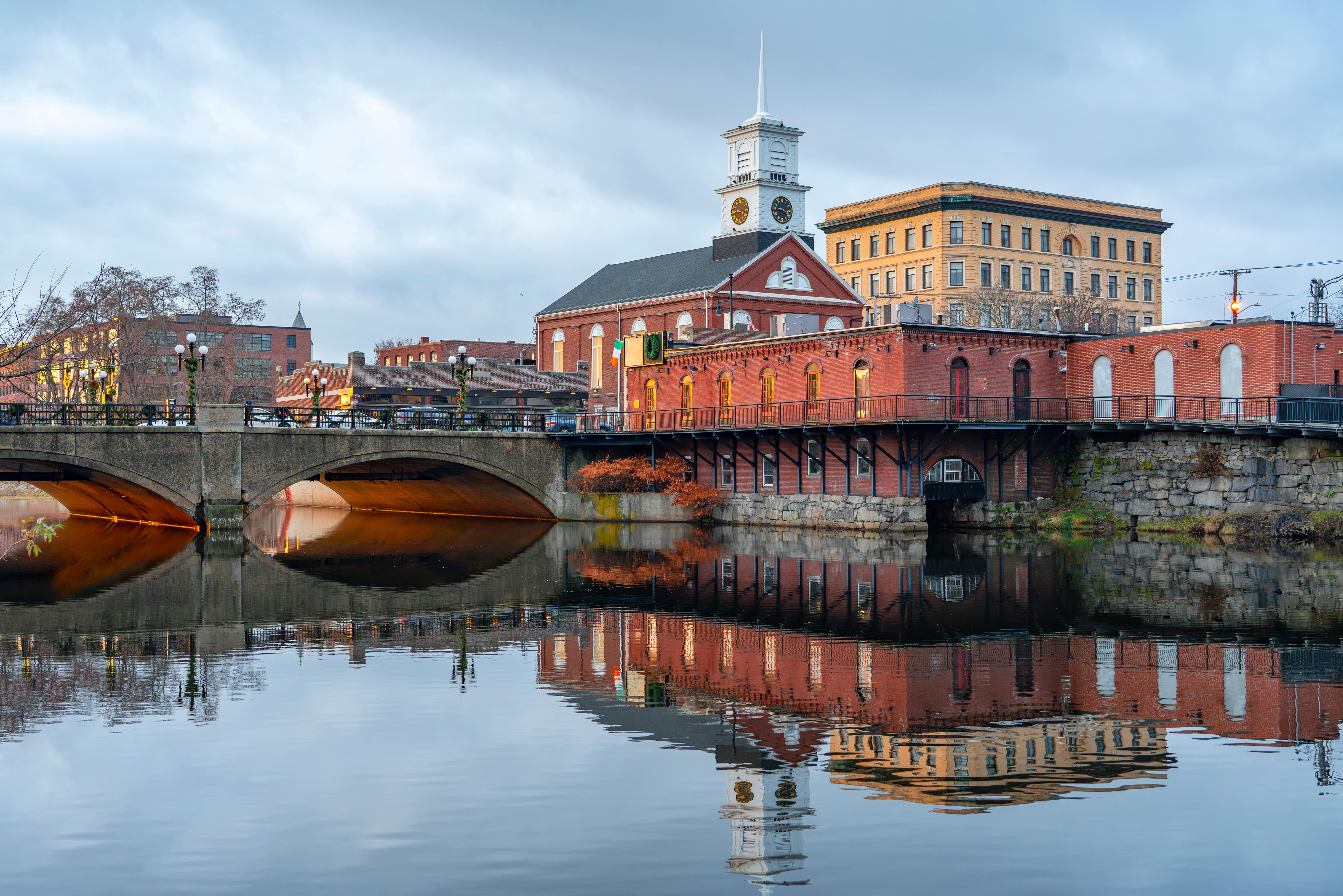 Downtown Nashua, NH riverfront and bridge reflecting in water.