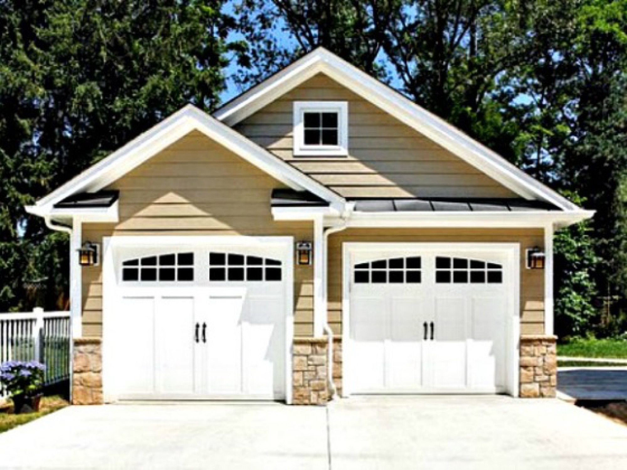 A two-door garage addition with carriage-style doors and stone detailing.