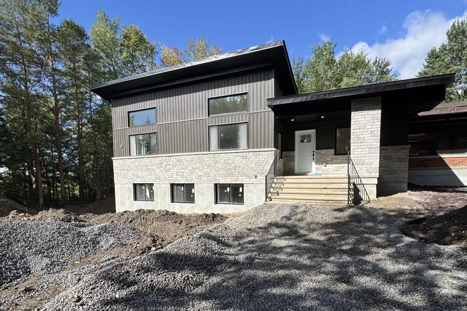 A two-level addition beside a Manotick bungalow with its own entrance, kitchen, laundry and four bathrooms, so a second household can live on the same lot.