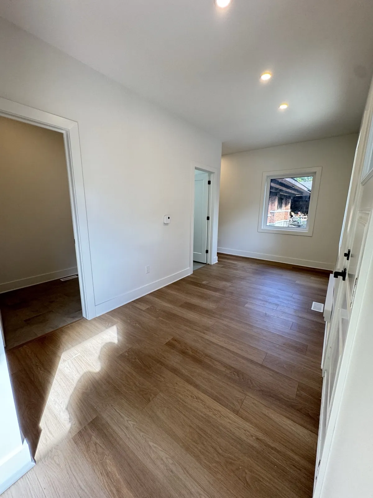 Hallway in the addition with a window looking back at the original brick house