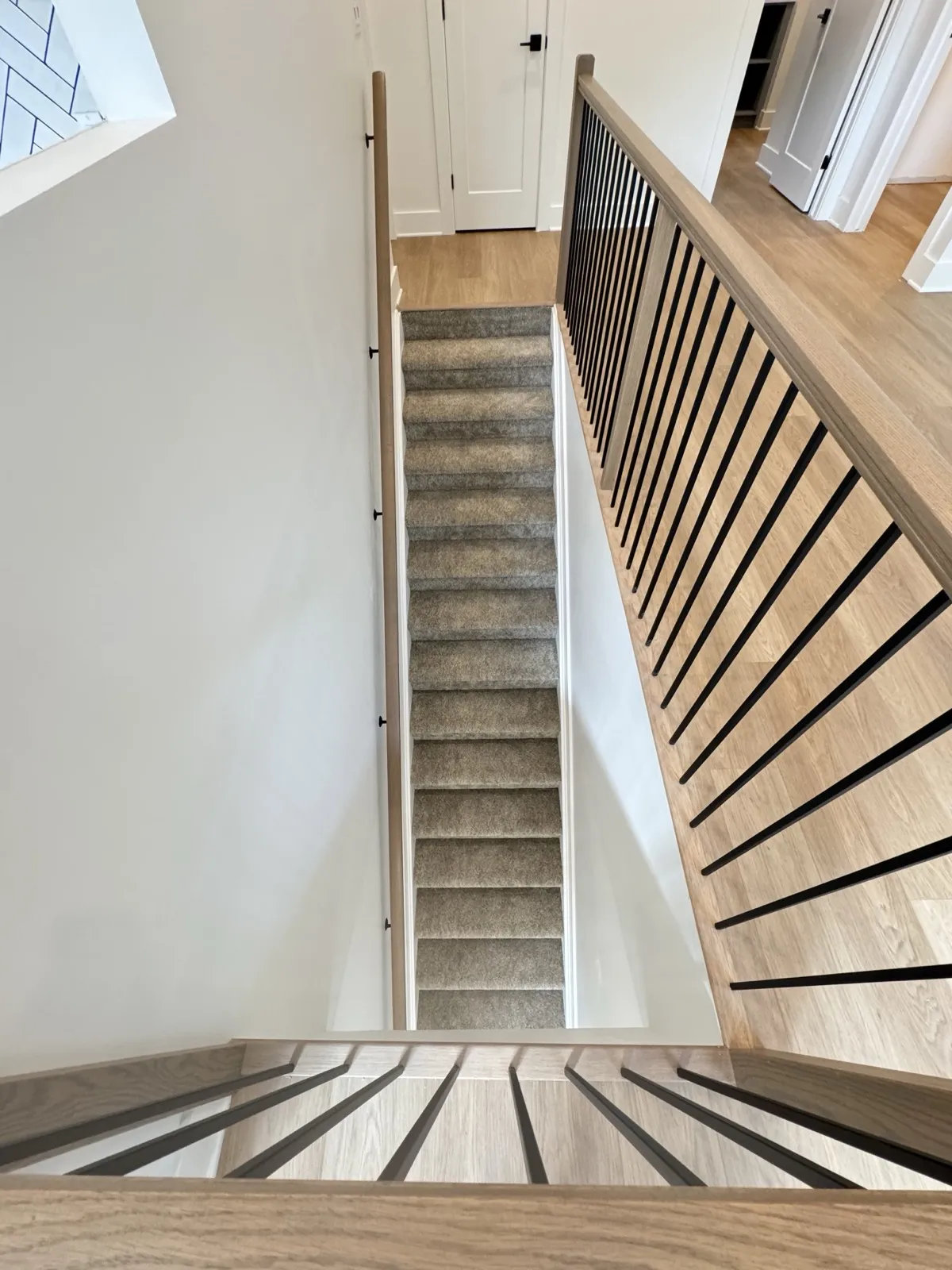 Oak and black-spindle staircase linking the two levels of the addition