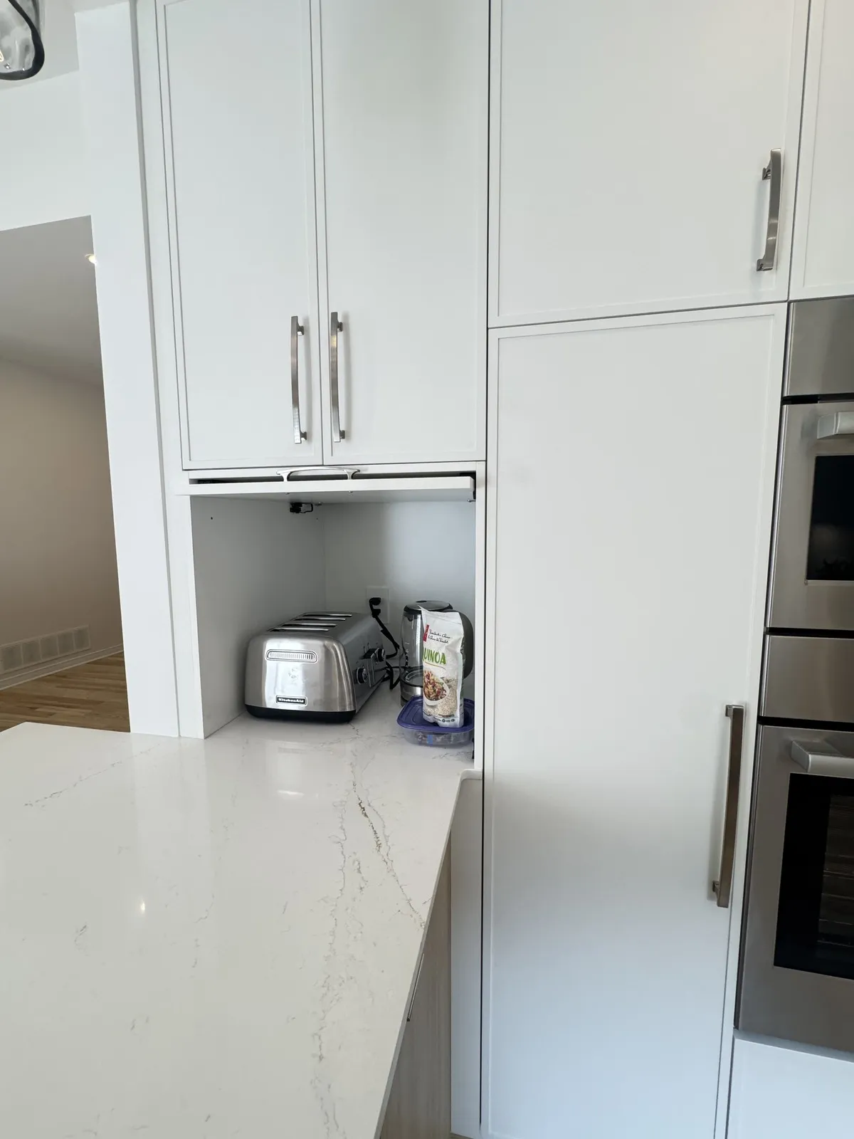 Appliance garage with lift-up door beside the wall ovens