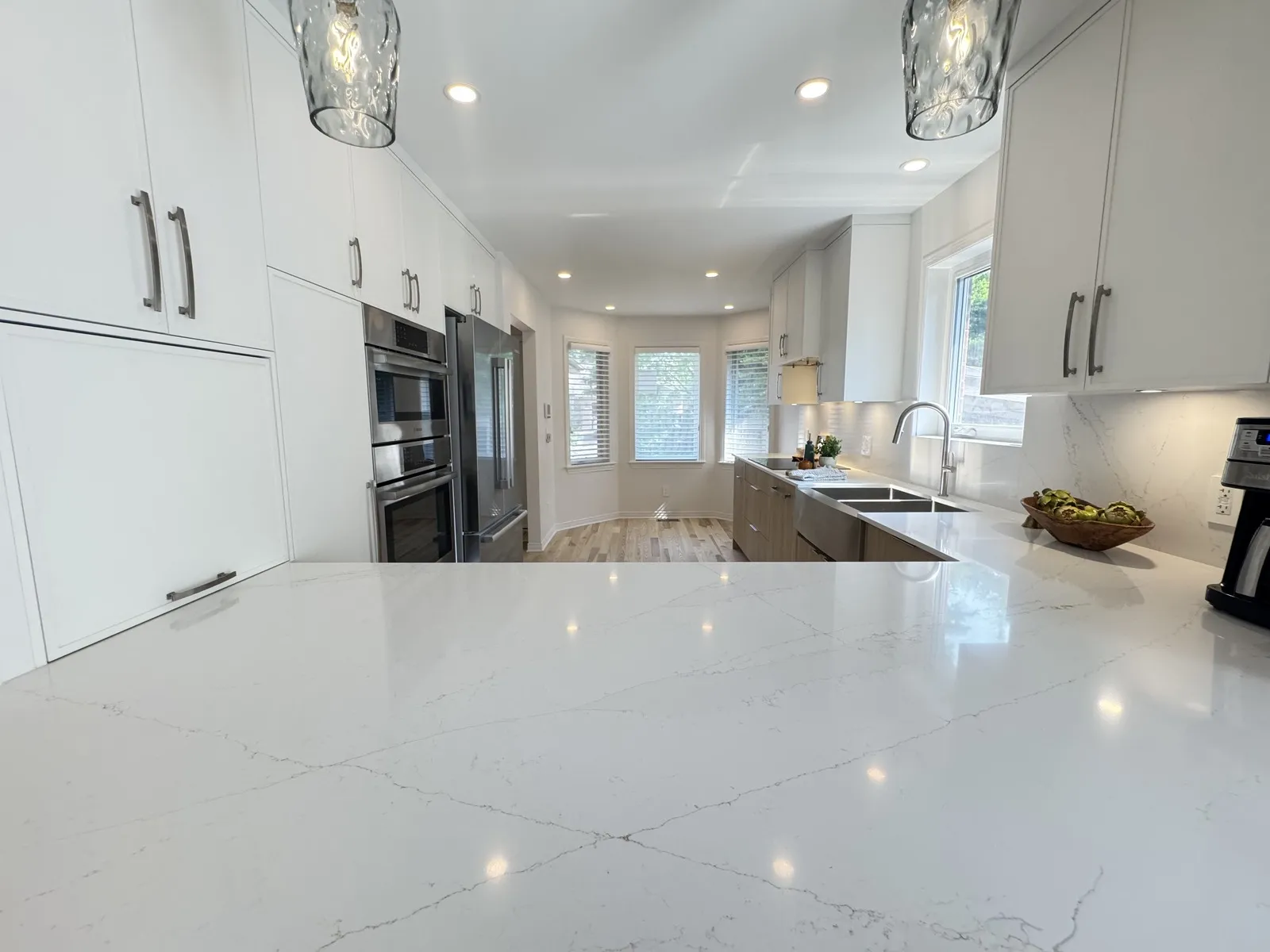 Quartz peninsula and wall ovens in a renovated Ottawa bungalow kitchen