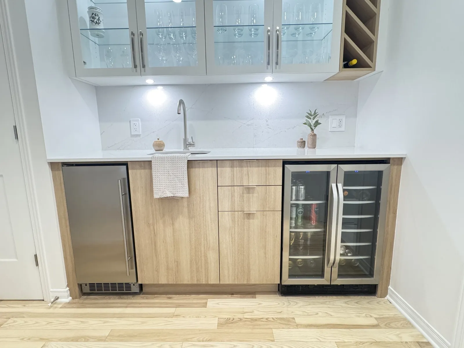 Main-floor wet bar with glass-front cabinets and beverage fridge