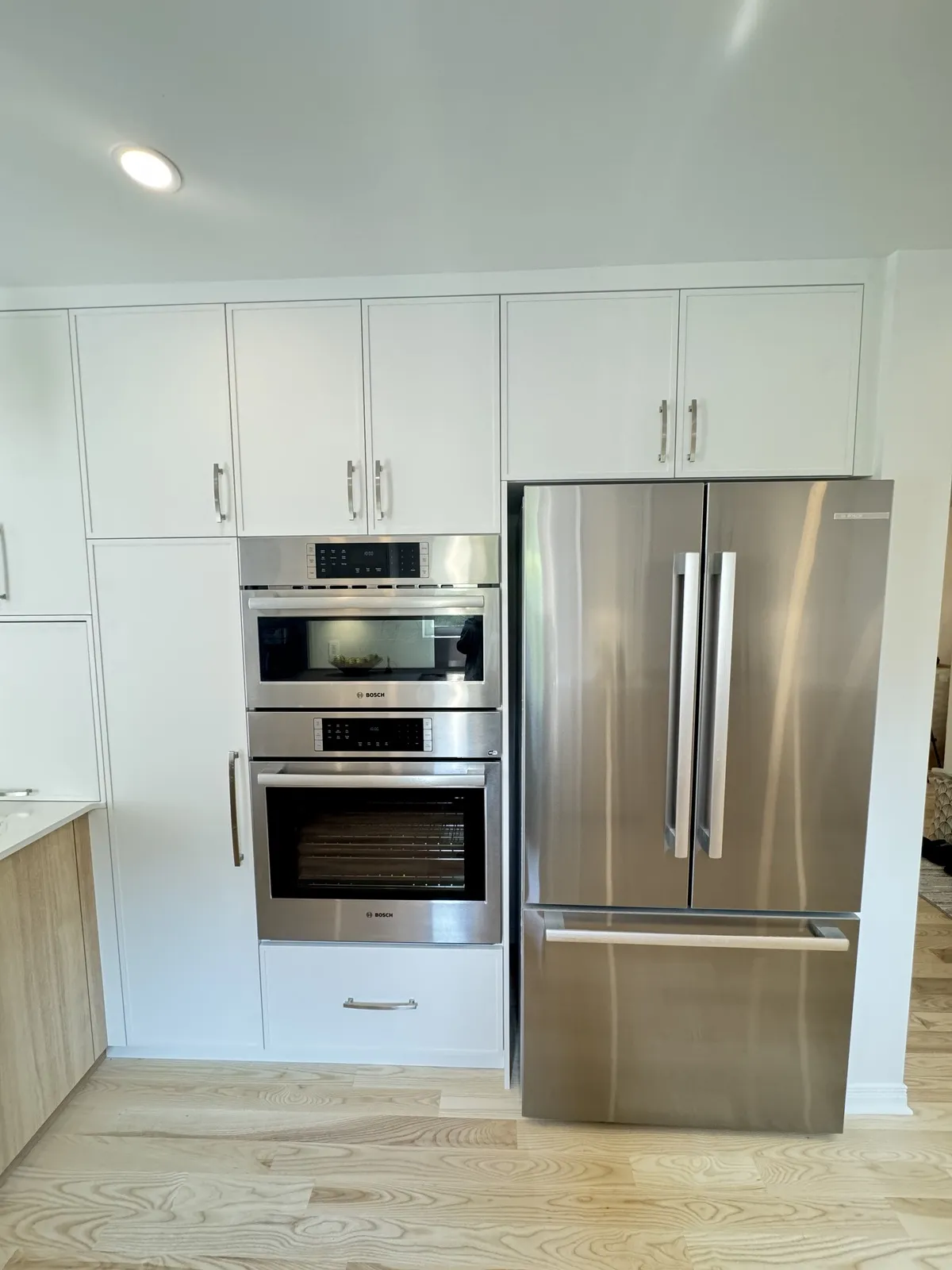 Double wall oven and fridge in tall white cabinets