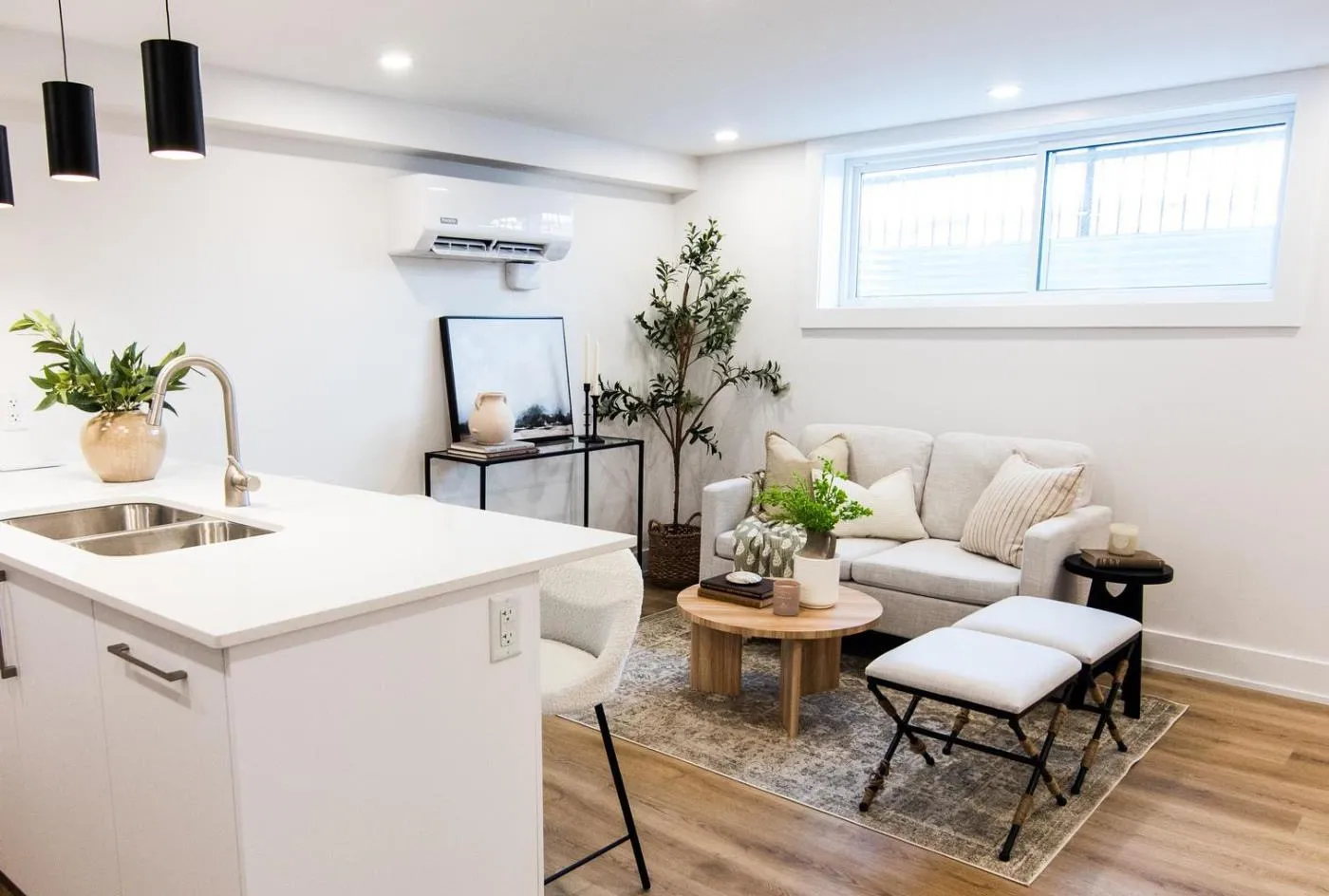 Basement suite living area with an above-grade window and quartz island