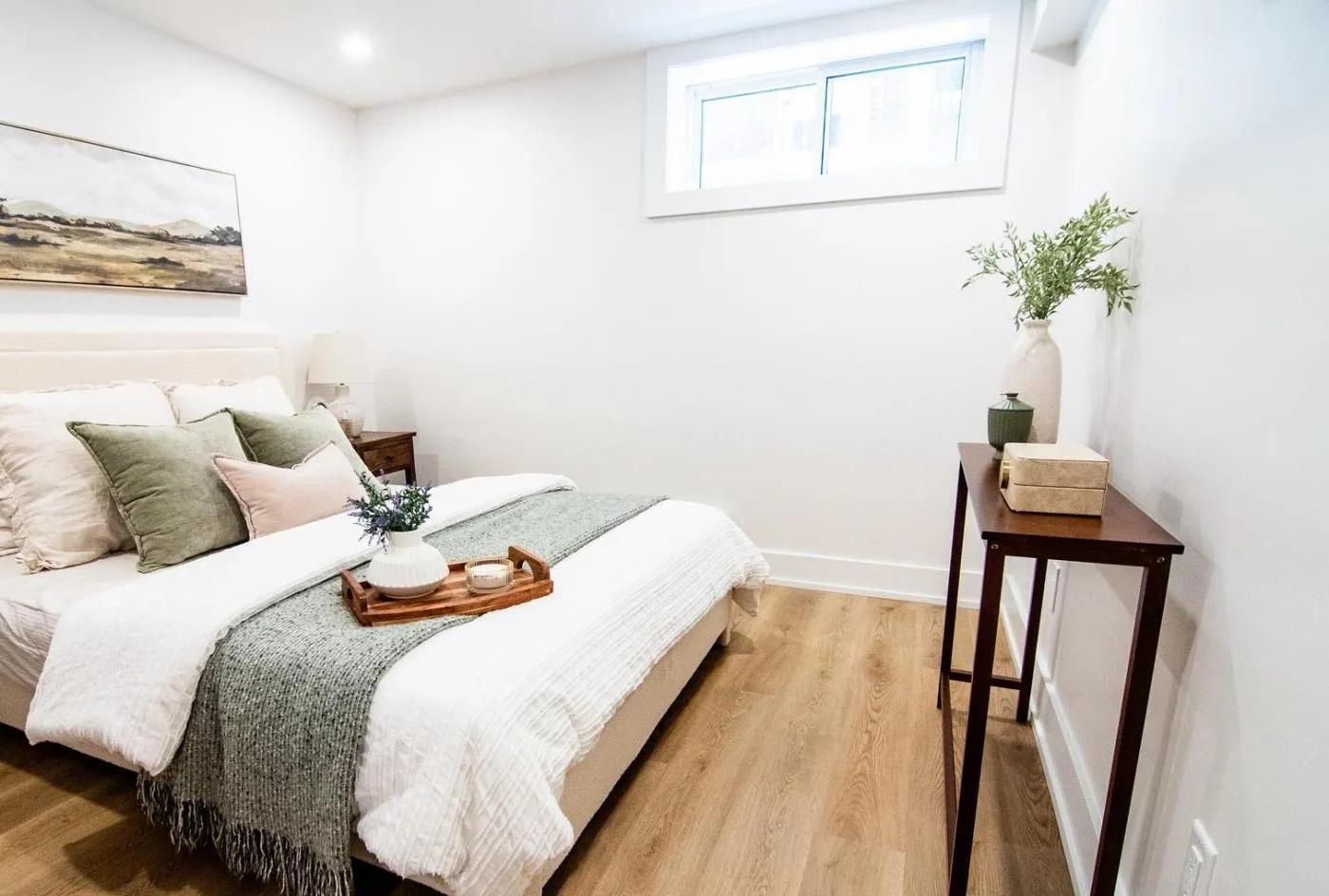 Basement suite bedroom with a new window and vinyl plank flooring