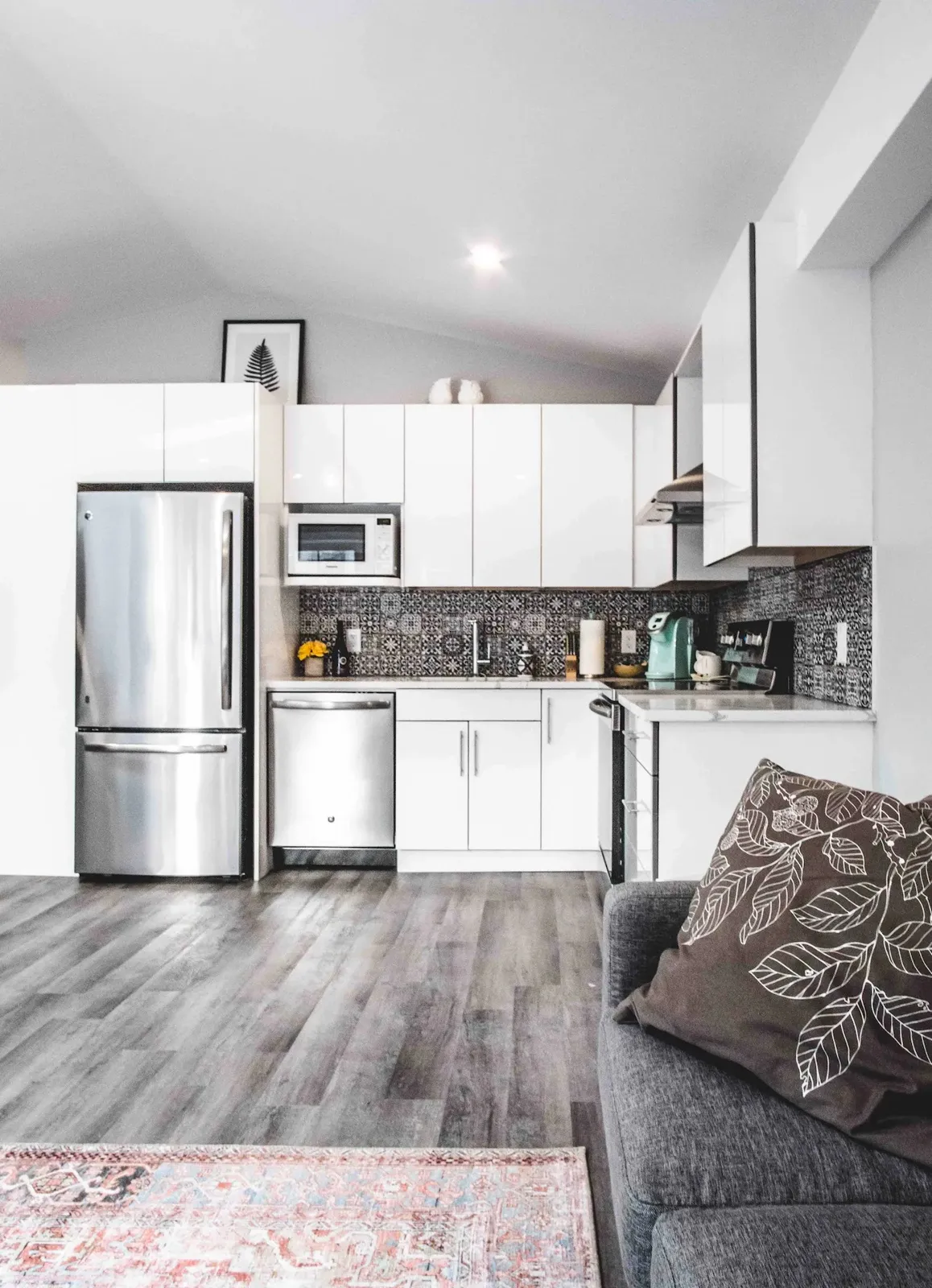 Open kitchen and living space in the coach house with vinyl plank floors