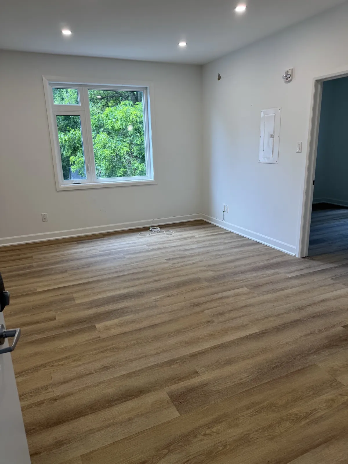 Bright unit living room with a large window and recessed lighting