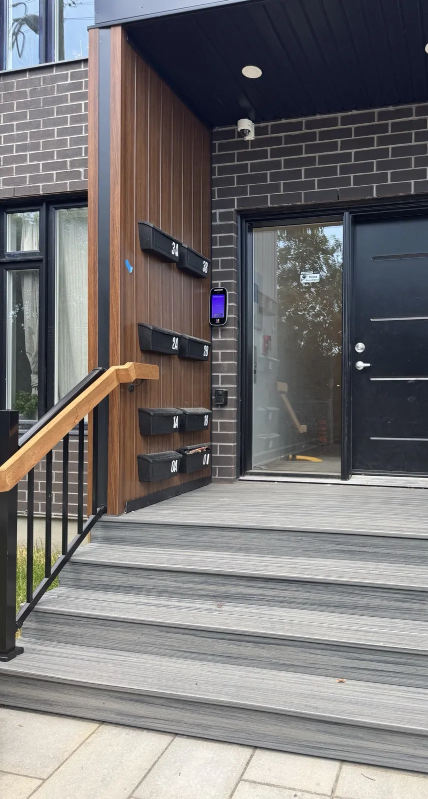 Front entrance with composite steps, a video intercom and a mailbox for each unit
