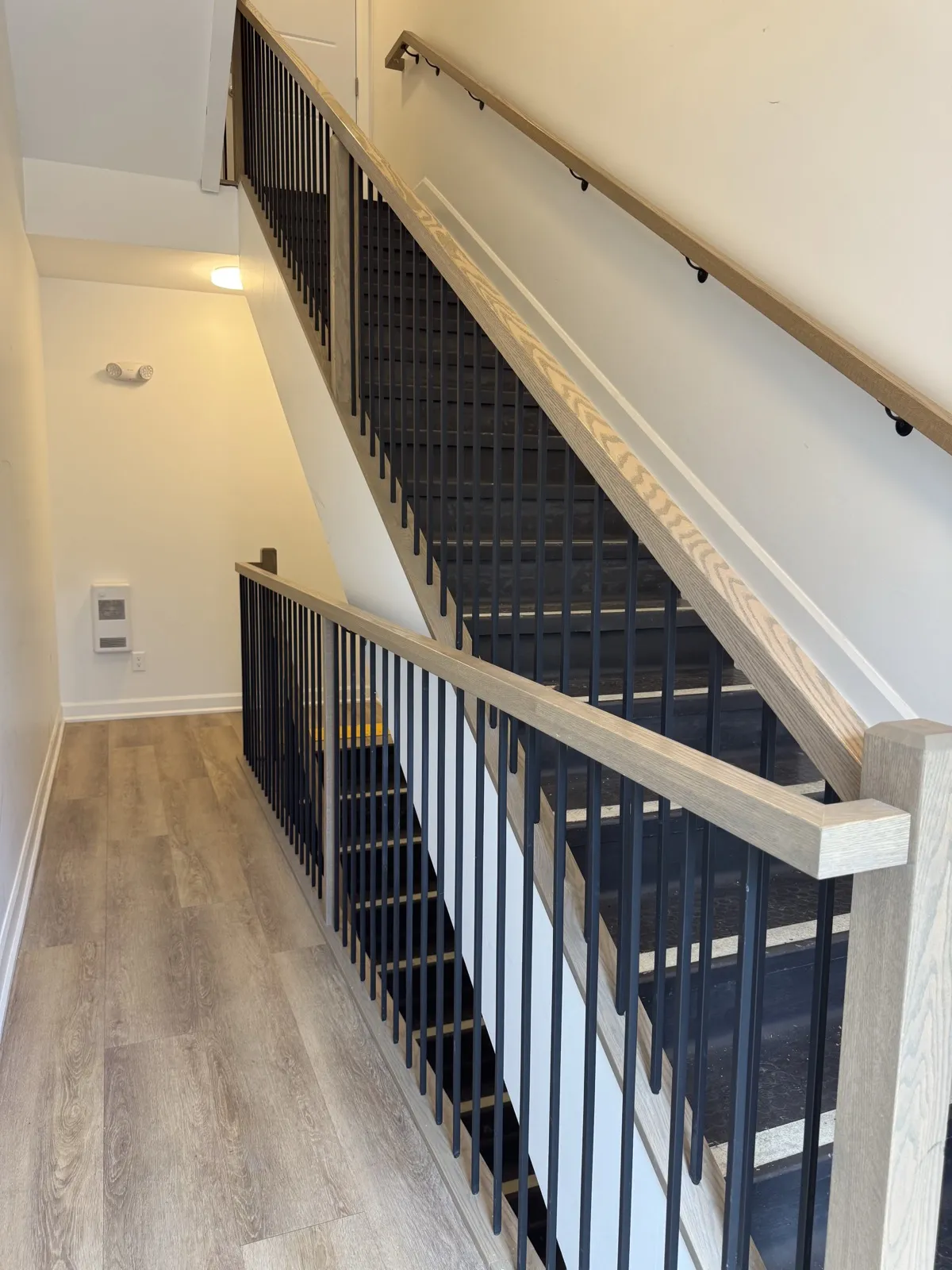 Common stair with oak handrails and black steel balusters