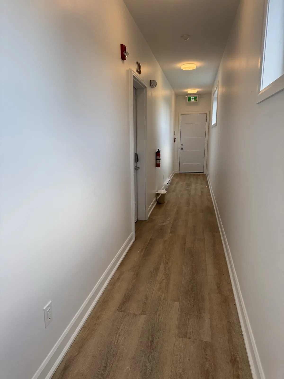 Common corridor with an exit door, exit sign and emergency lighting
