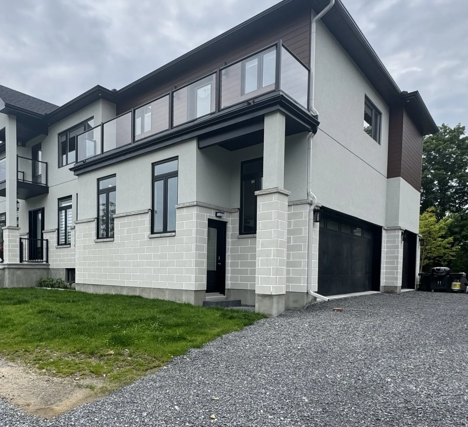 A new two-storey custom home on a treed lot in Onassa Springs, with a three-car garage, four ensuites and a separate one-bedroom secondary unit built at the same time.
