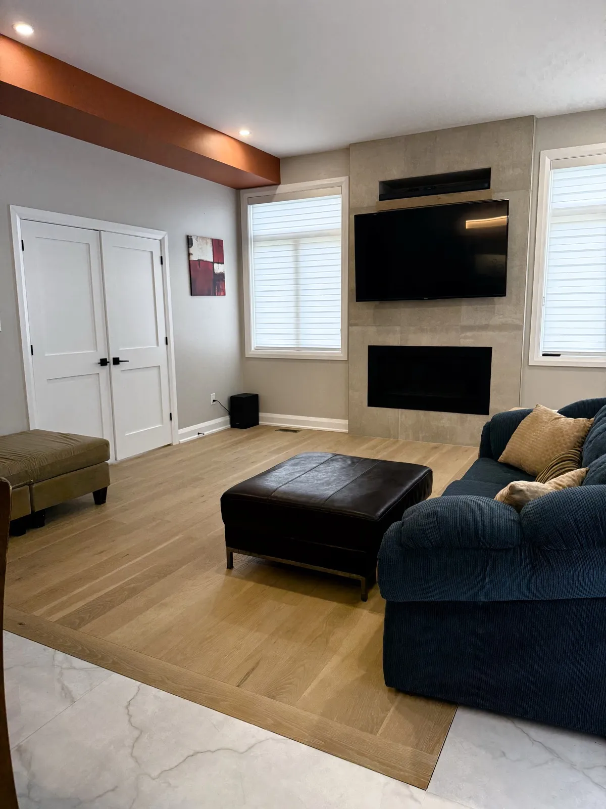 Family room with a tiled fireplace wall and wide-plank oak floor