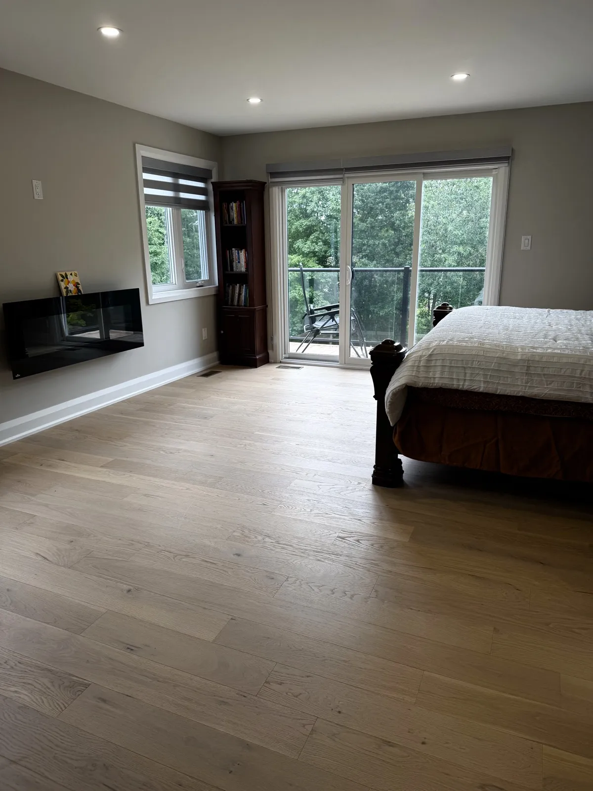 Primary bedroom with a linear fireplace and sliding door to the balcony