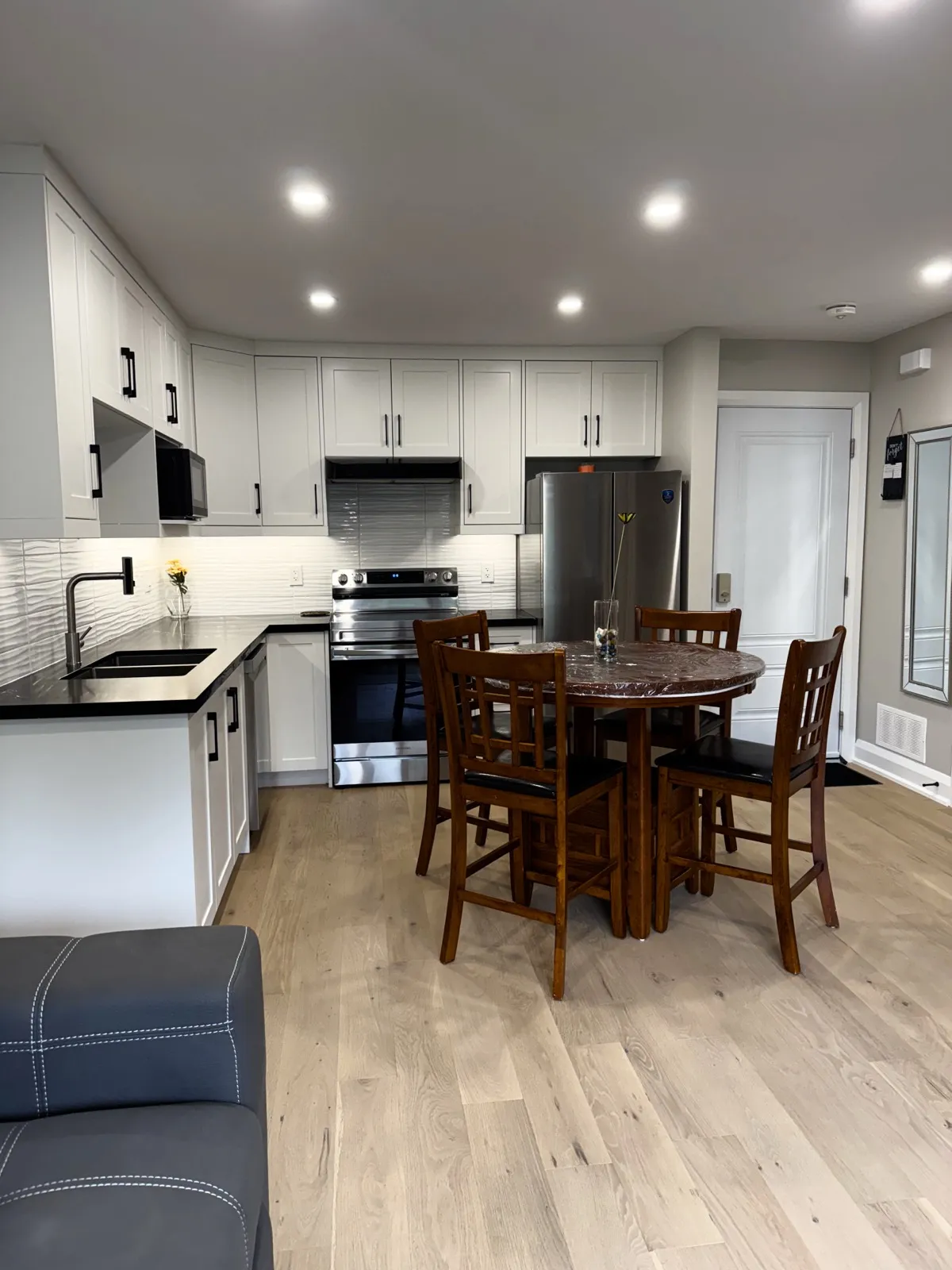 Secondary dwelling unit kitchen and dining area with white Shaker cabinets and stainless appliances