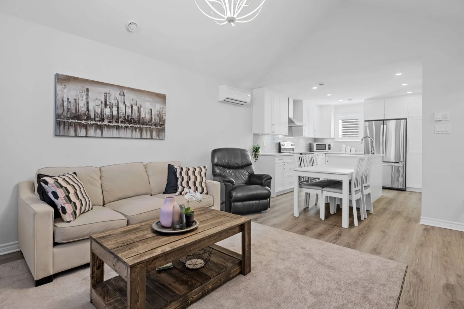 Open living room and kitchen under a cathedral ceiling with a ductless mini-split