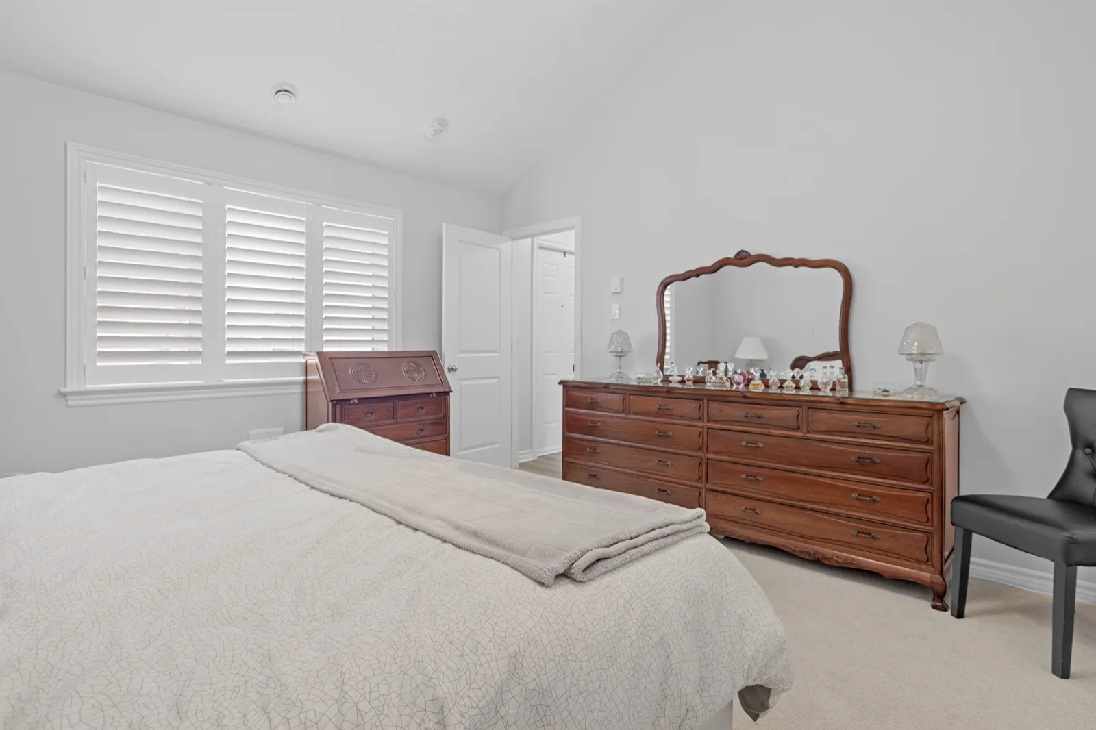 Coach house bedroom with a vaulted ceiling and California shutters