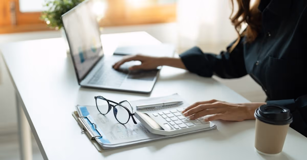 Iemand aan een bureau met een laptop en kladblok