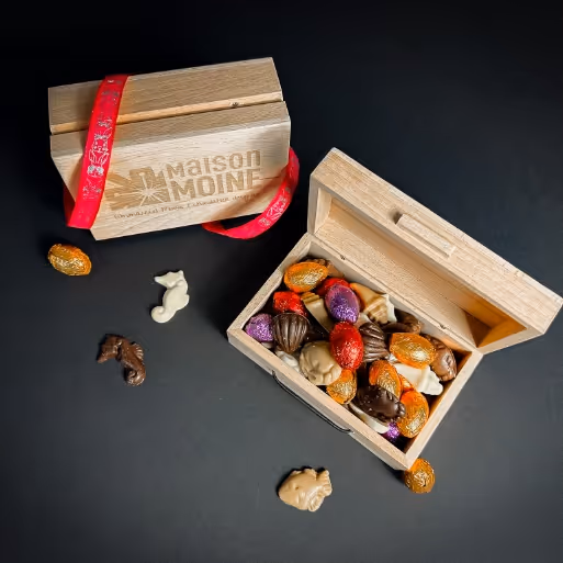 Le coffret de chocolat de Pâques en bois authentique est un véritable plaisir pour les yeux et les papilles. Gourmande, il est conçu pour ravir vos sens. À l'ouverture du coffret, une explosion de couleurs et de saveurs se révèle, avec une sélection exquise de fritures en chocolat et d'œufs fourrés, représentant le summum de l'expertise chocolatière.