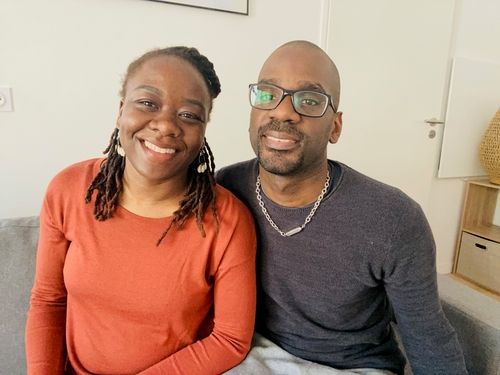 A man and a woman sitting on a couch.