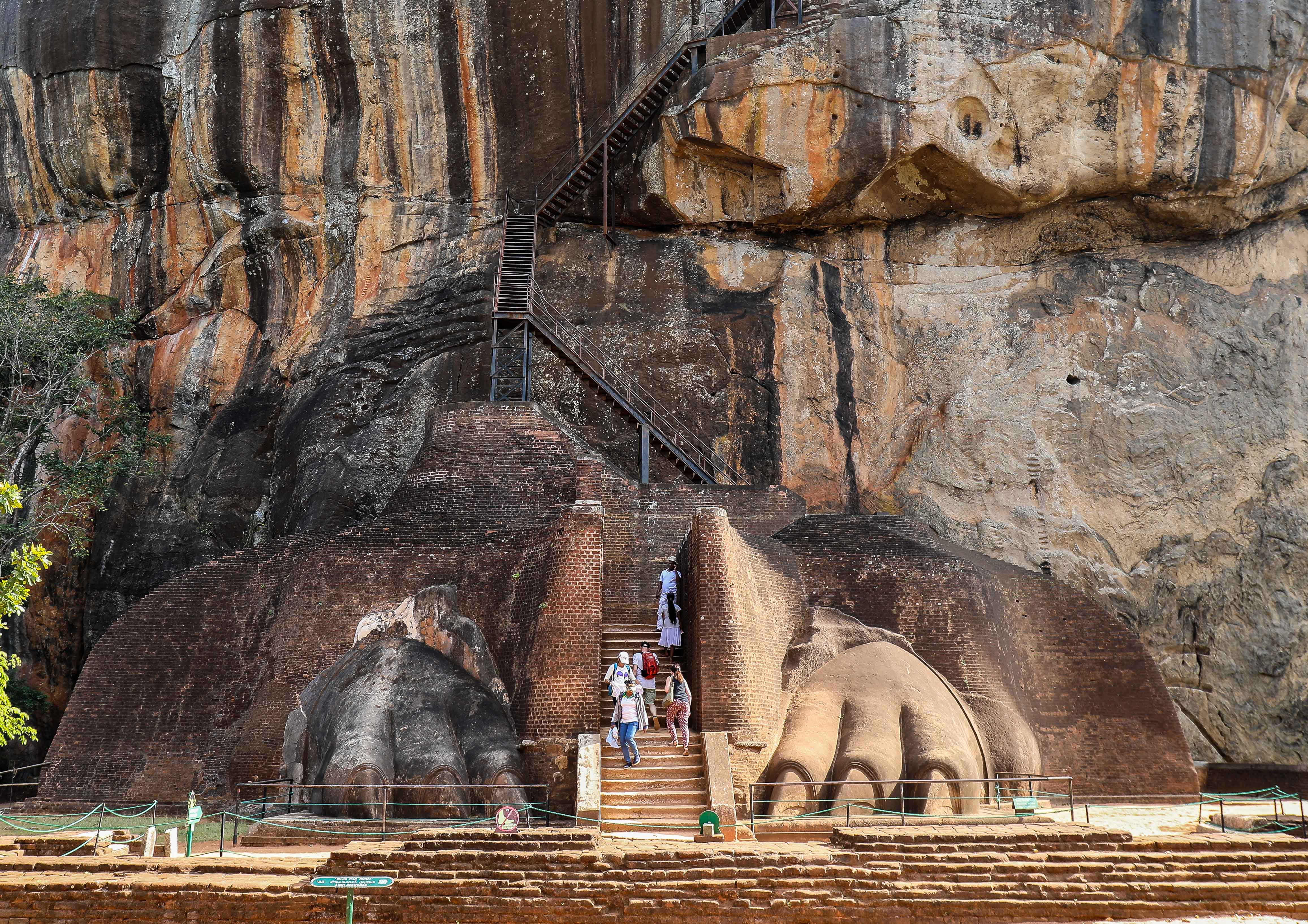 Visitors climbing the stone lion’s paws entrance at Sigiriya Rock Fortress