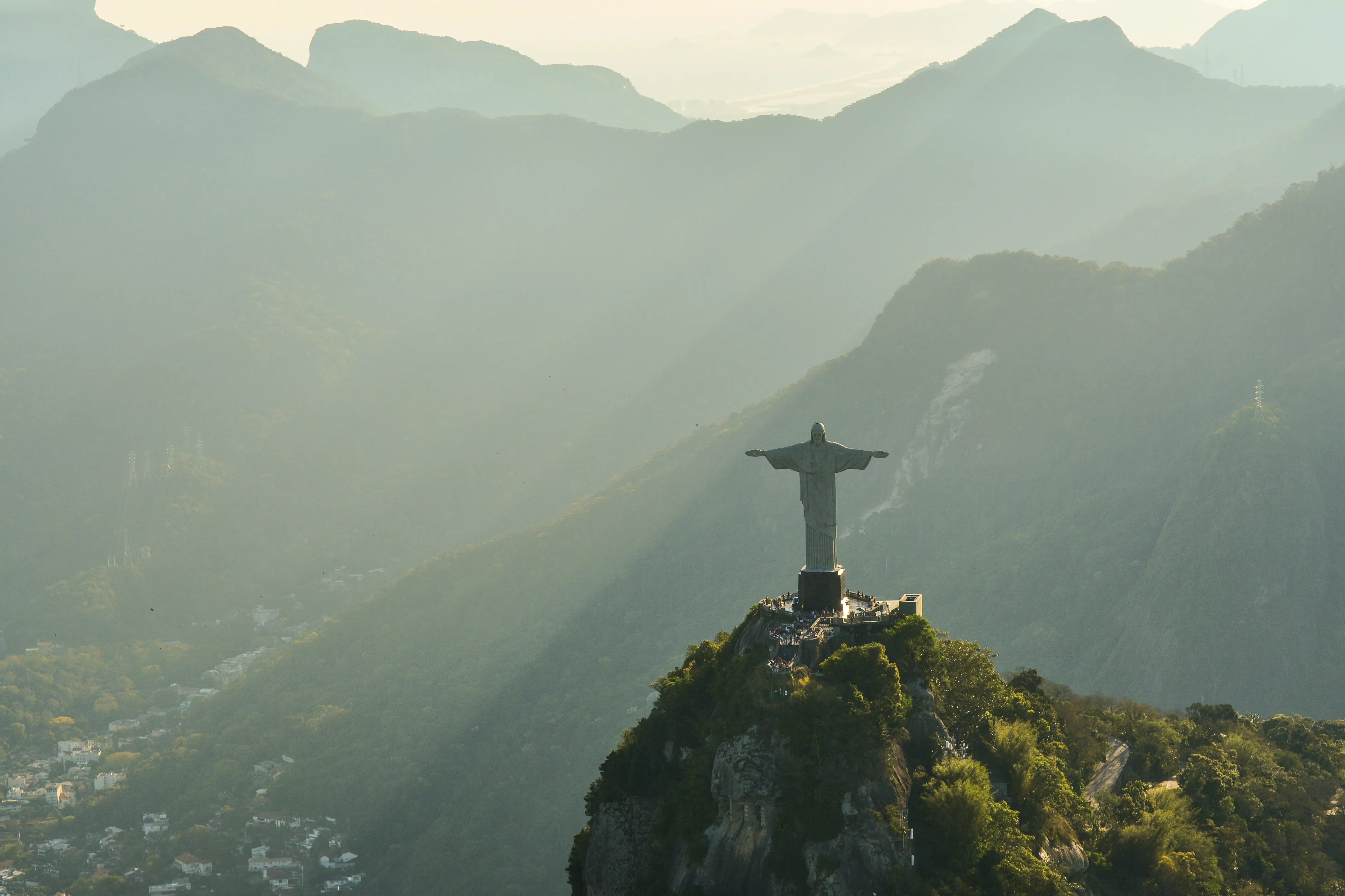 The Christ the Redeemer statue atop a mountain overlooking misty hills in Rio de Janeiro, Brazil