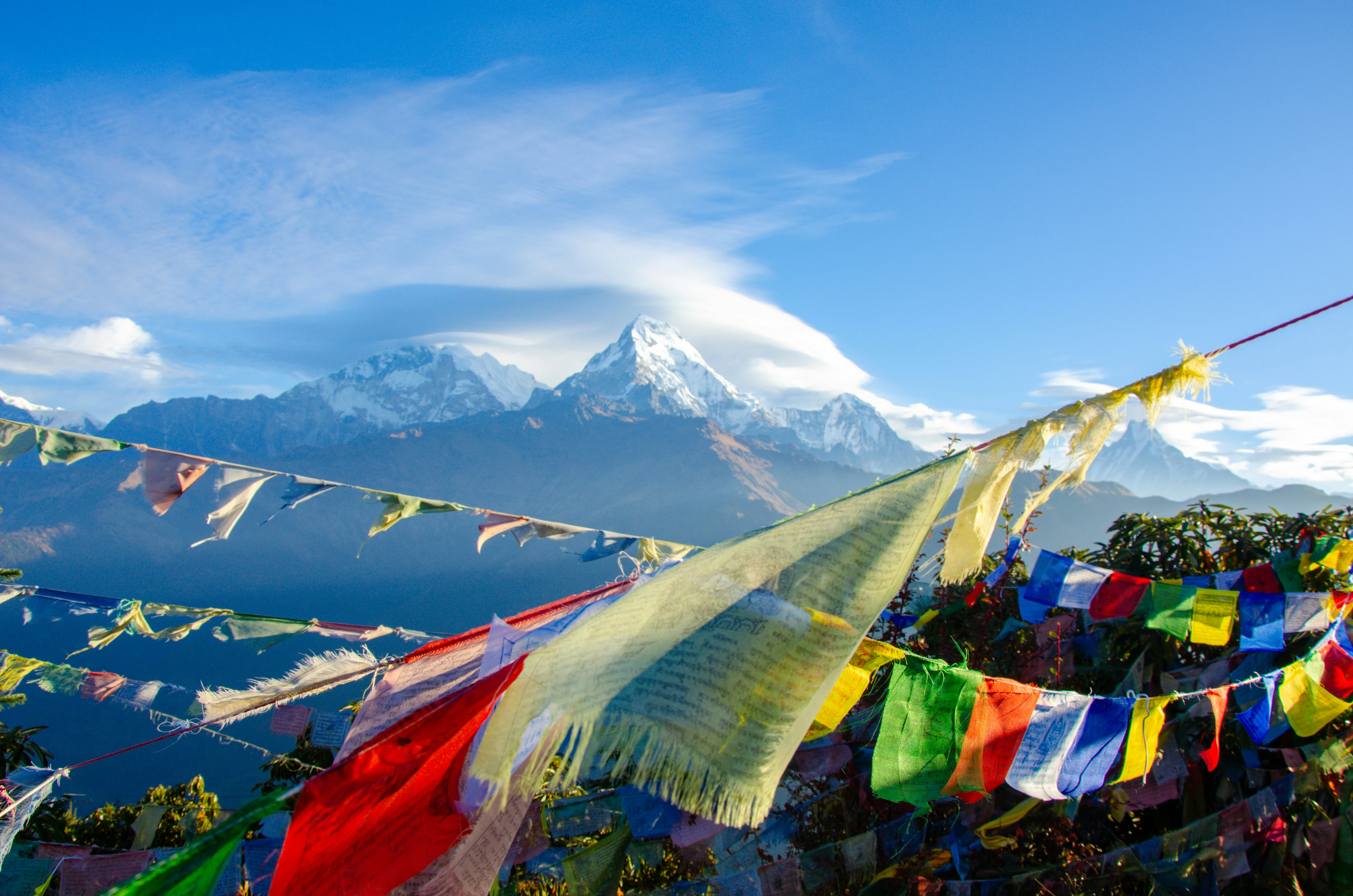 Colourful Buddhist prayer flags strung before snow-capped Himalayan peaks in Nepal