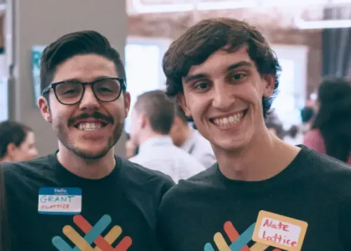 two men wearing t - shirts with stickers on them
