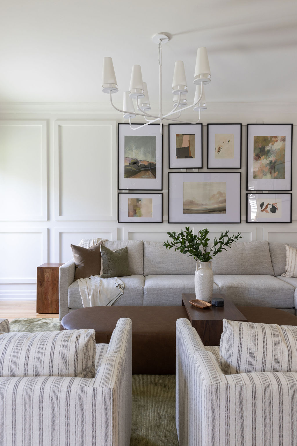 striped arm chairs and gallery wall with custom ottoman