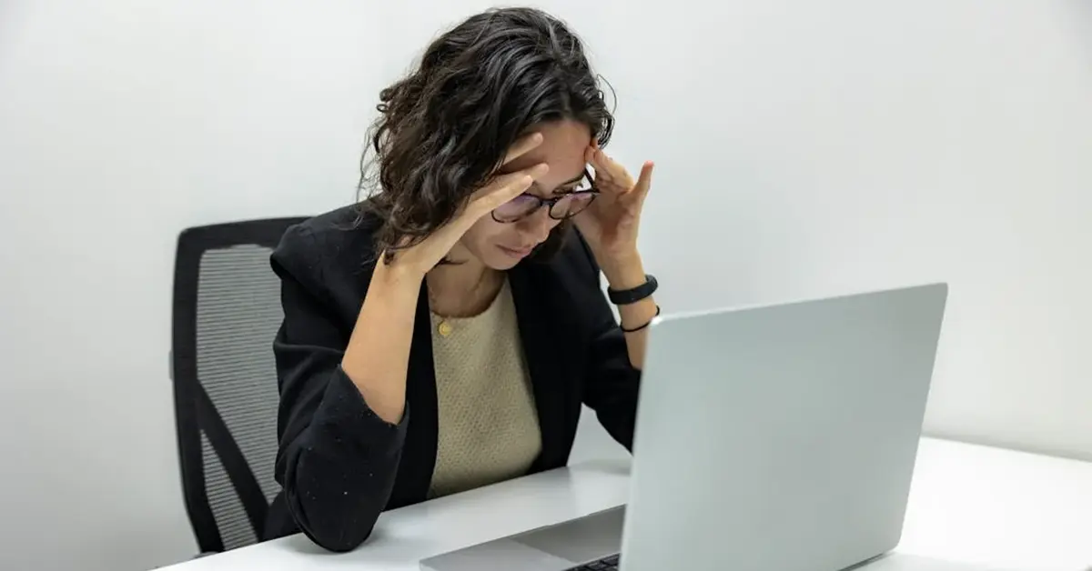 A person sits a desk looking at laptop