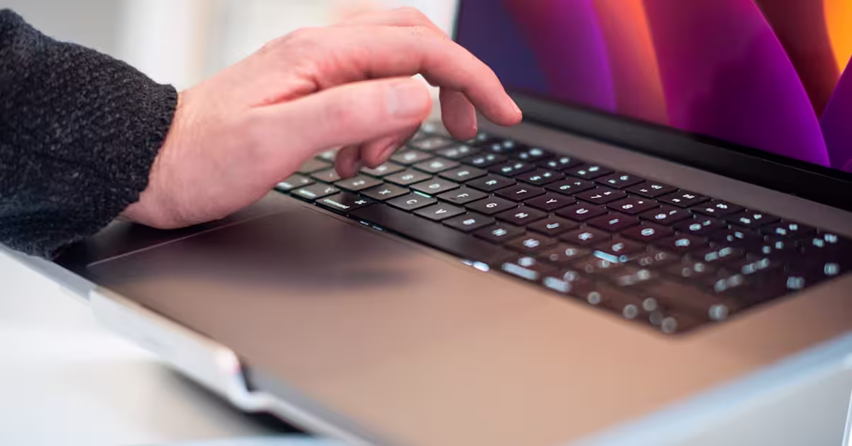 A person's hand oers above a laptop keyboard