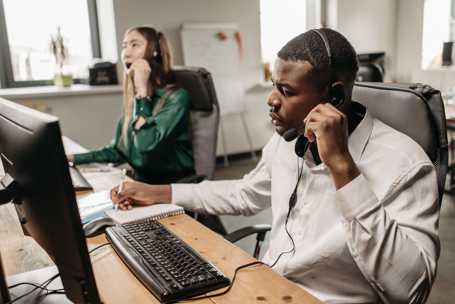 A focused team of customer service representatives working on computers and answering calls in an office.