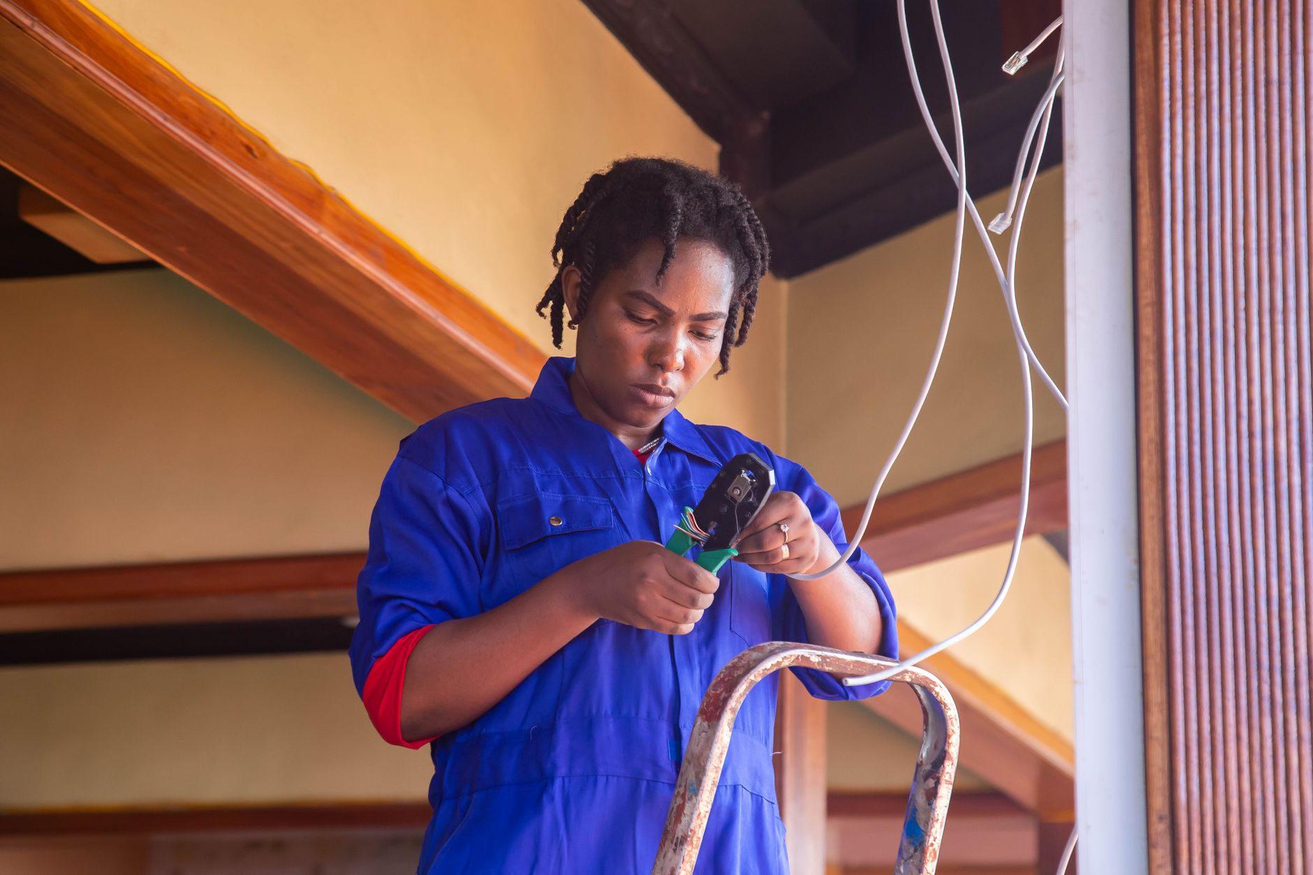 Professional electrician working on wiring in an indoor setting.