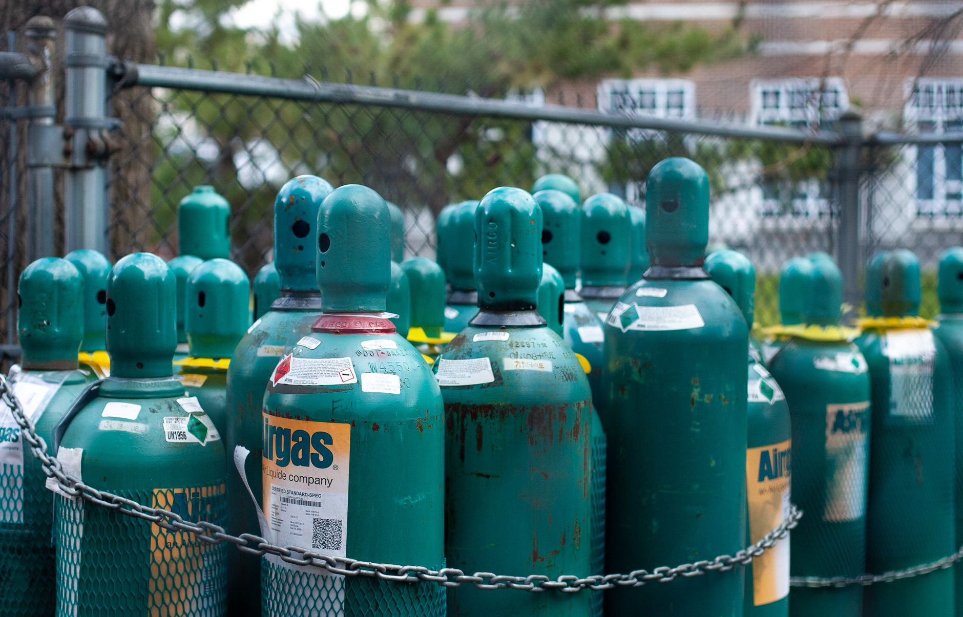 Gas cylinders stored in a locked cage outside a store