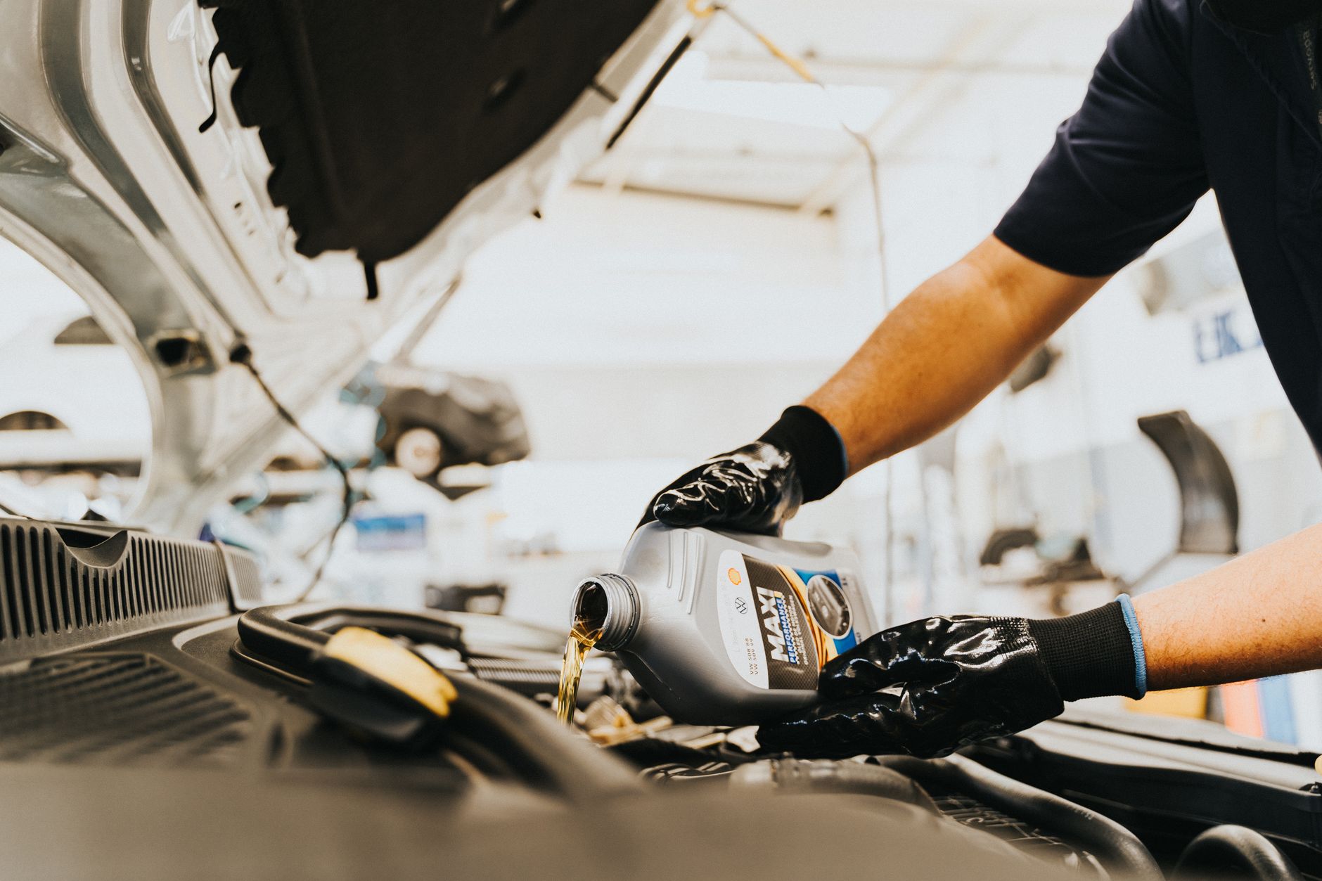 Technician pouring new oil during an oil change